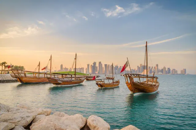 Dhows traditionnels devant la skyline de Doha, au coucher du soleil